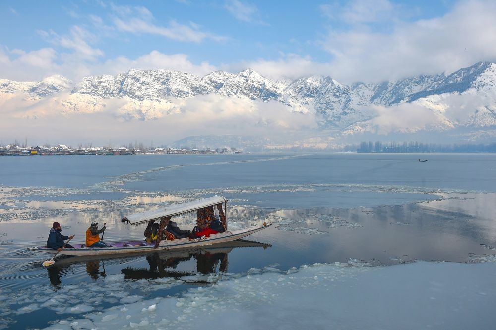 Srinagar: Tourists take a 'shikara' ride across Dal Lake with snow clad Zabarwan mountains in the backdrop, in Srinagar, Wednesday, Jan. 6, 2021. (PTI Photo/S. Irfan)
